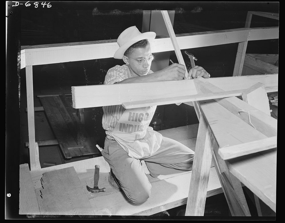 Production. Motor torpedo boats (wooden). An African American carpenter working on the framing of a motor torpedo boat at a…