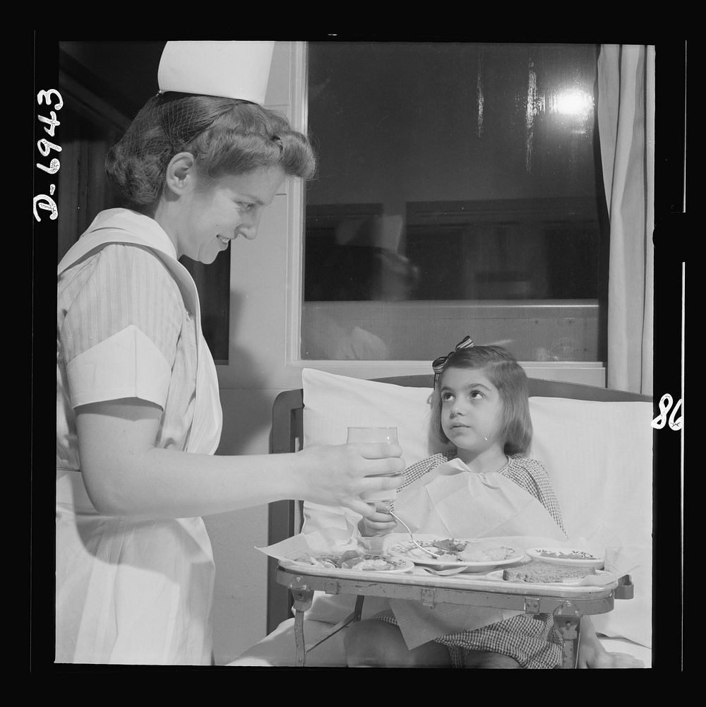 Nurse training. A convalescing youngster gets lunch with a smile from a student nurse. Sourced from the Library of Congress.