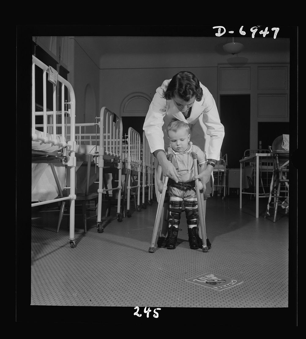 Nurse training. A student nurse, acting as physical therapist, points to the picture book, encouraging a child to learn to…