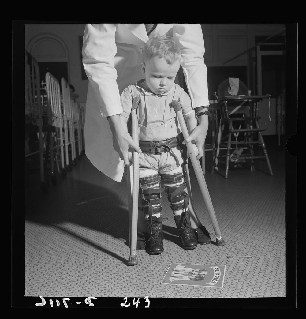 Nurse training. A student nurse, acting as physical therapist, points to the picture book, thus encouraging this toddler to…