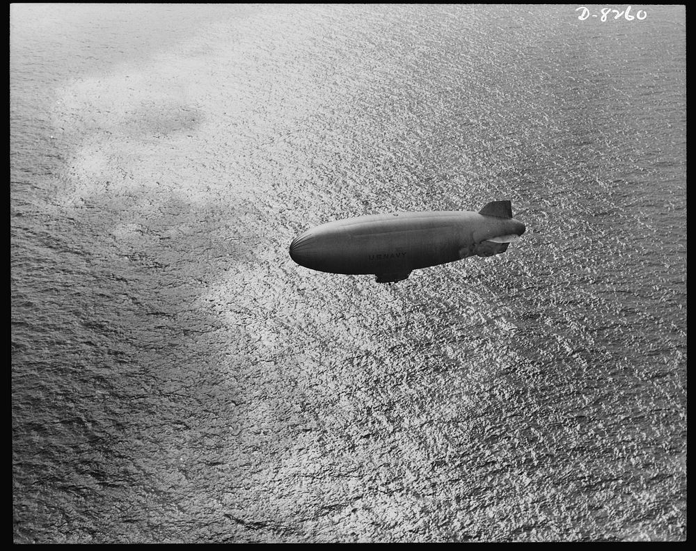 U.S. Navy starts out on patrol duty. Soaring over the Atlantic Ocean, a U.S. Navy blimp is silhouetted against the sparkle…
