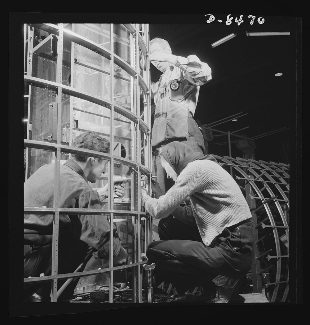 Production. B-17 heavy bomber. Men and women work together to complete a fuselage framework for a new B-17F (Flying…