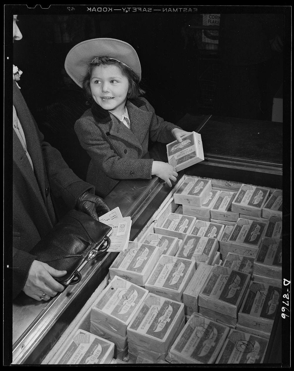 Preparation for point rationing. While mother keeps handy her war ration book two, daughter examines the frozen foods which…
