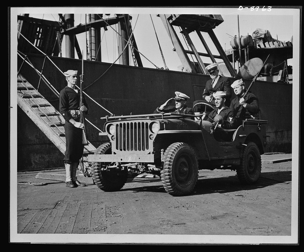 Coast Guard anti-saboteur patrol. A Coast Guard officer is shown at an East coast port with armed Coast Guardsmen in a jeep…