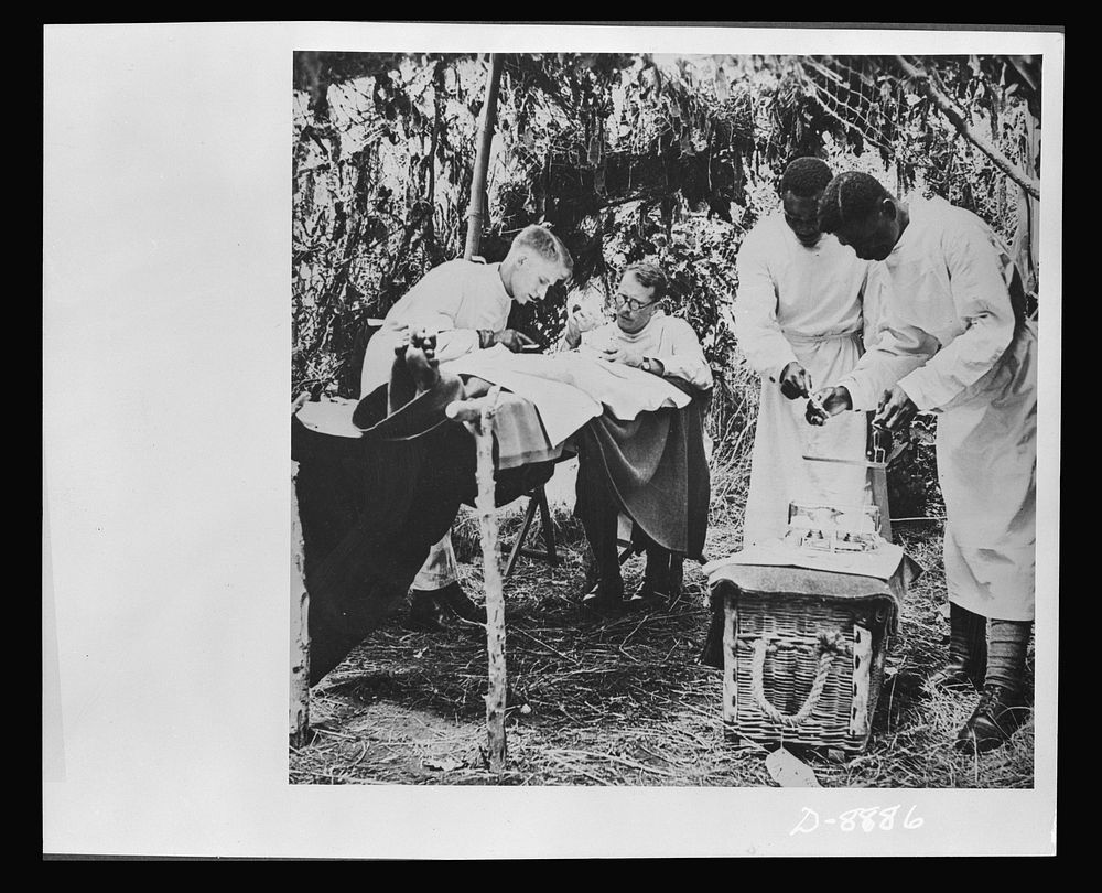 Advanced dressing station in West Africa. An operation is performed in a camouflaged operating station while native Africans…