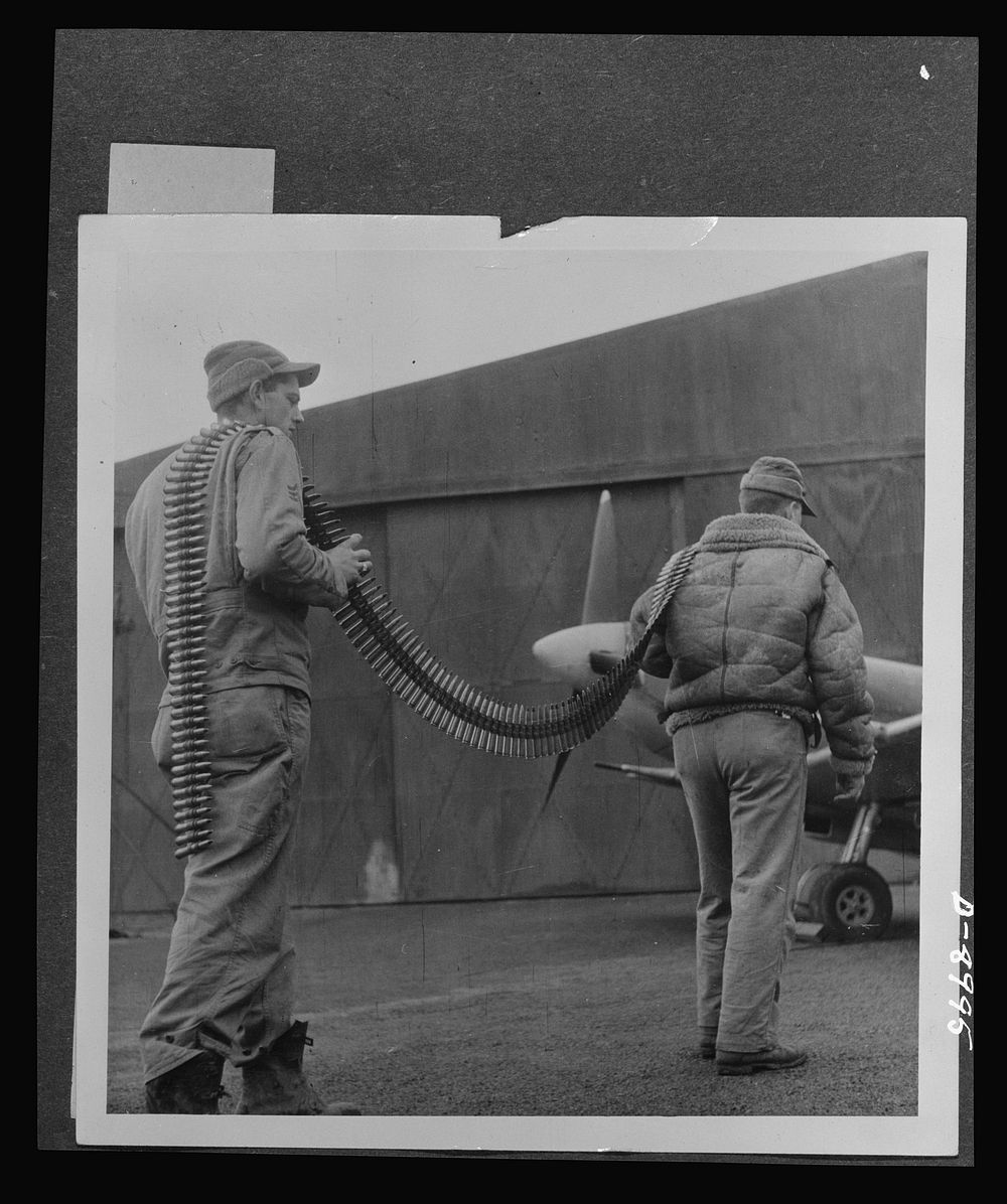 Reciprocal aid. Two sergeants from Texas, Sergeant A. Baker and Technical Sergeant Roy Hill, carry a string of British…