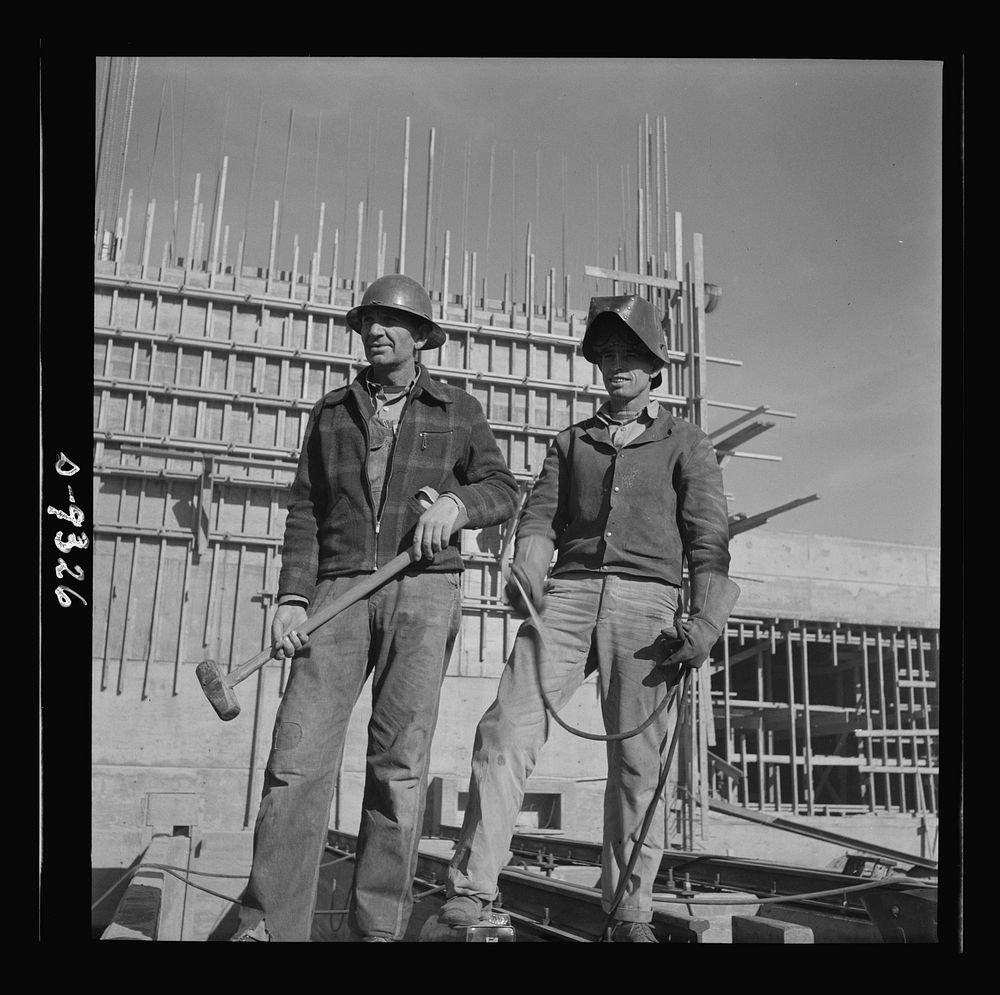 Production. Magnesium. A rigger and a welder at the new Basic Magnesium plant in the southern Nevada desert look out across…