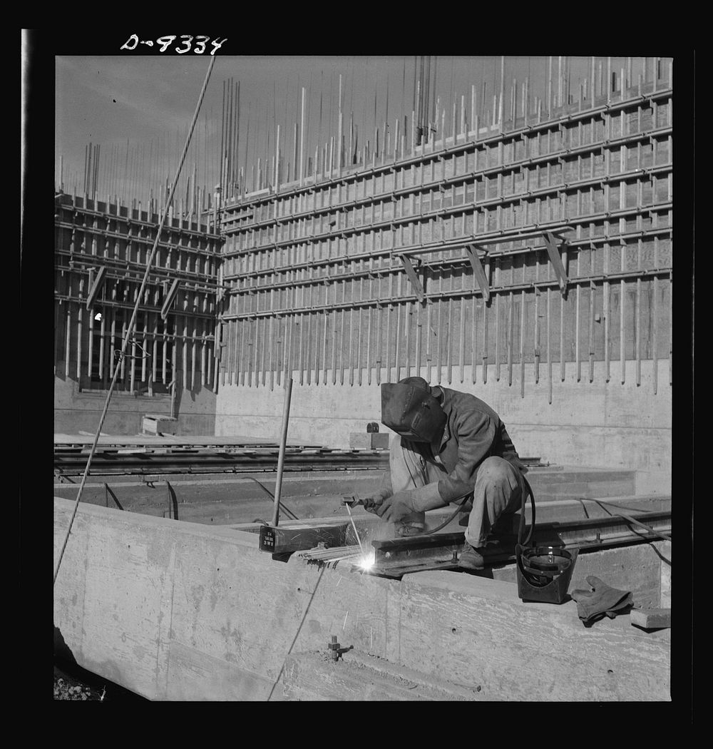 Production. Magnesium. A helmeted welder is busily engaged in his part of the war effort at Basic Magnesium's huge plant in…