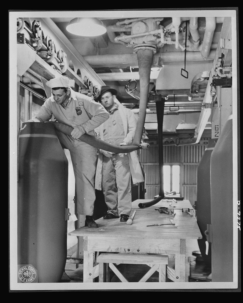 Production. Shell loading. Nonchalantly loading a two-ton "block buster" at a large Midwest plant. Every precaution is…
