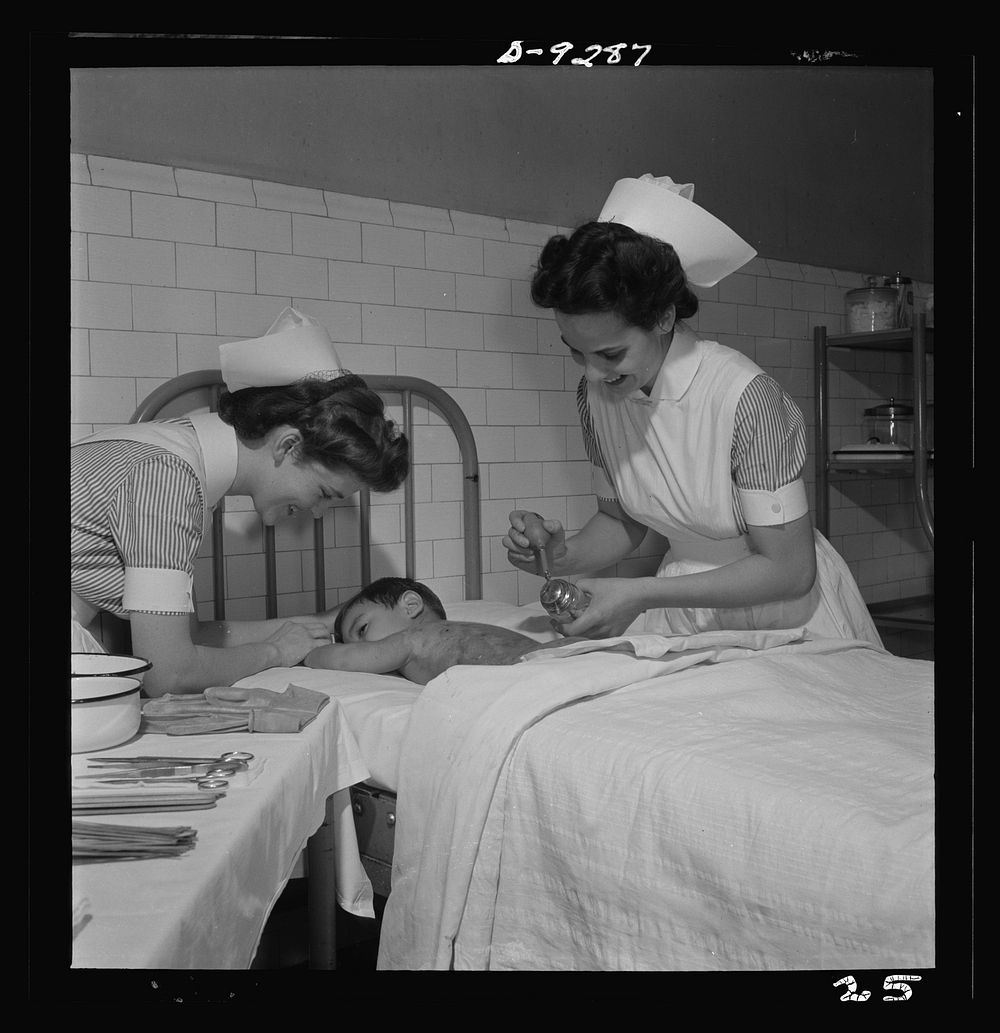 Nurse training. Nurses learn the care of patients suffering from burns. Here, the nurse paints a boy's burned back with…