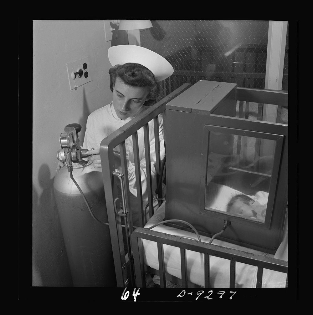 Nurse training. A student regulates the oxygen flow into this tiny oxygen box where a premature infant "lives". Sourced from…