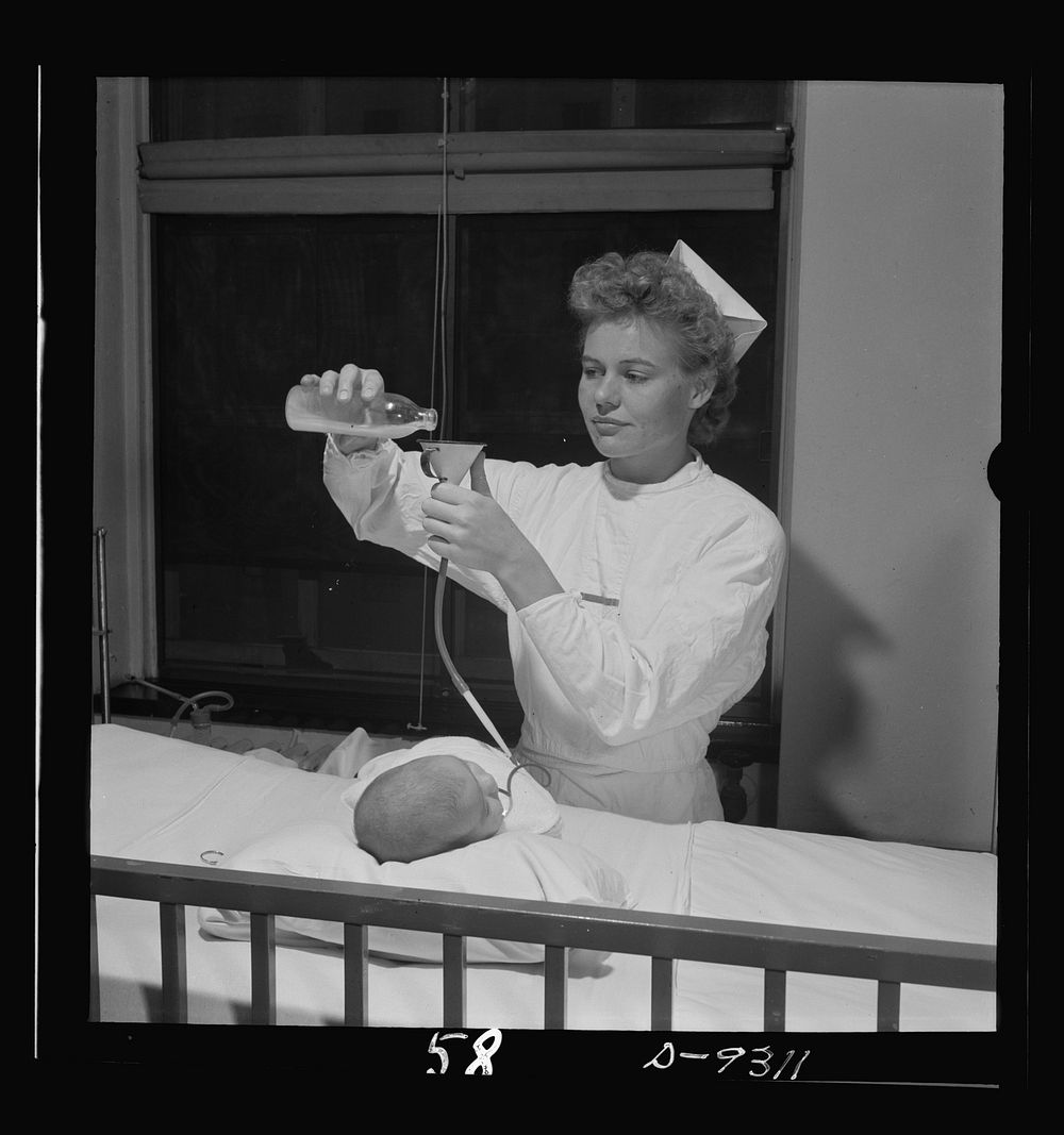 Nurse training. A nurse gives this weak infant its meal through the Gavage method. Sourced from the Library of Congress.