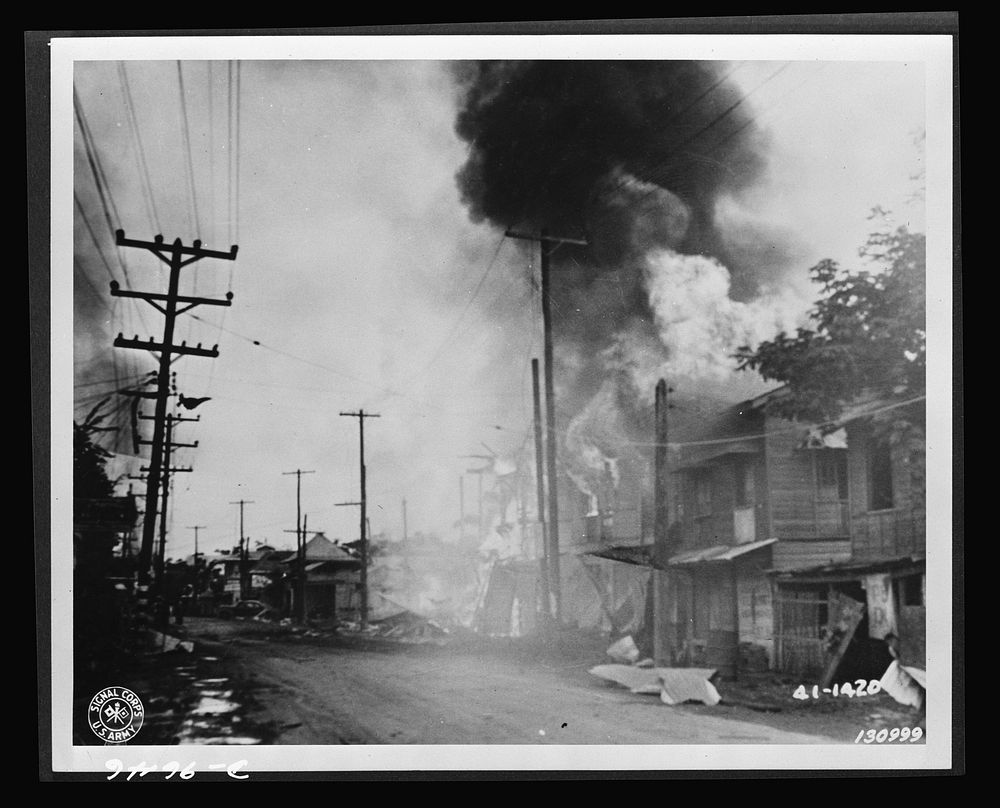 A burning building along Taft Avenue which was hit during the Japanese air raid in Barrio, Paranque, December 13, 1941, the…