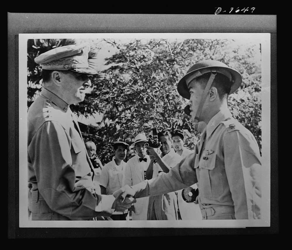 General Douglas MacArthur, left, congratulates Captain Villamor of the Philippine Air Force, after awarding him the…