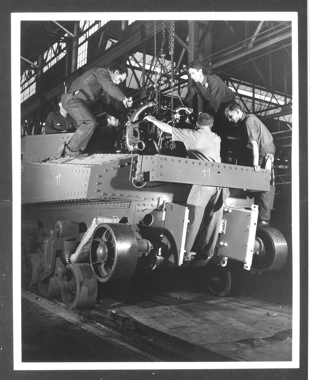 Chrysler tank arsenal. Installing the power plant is a ticklish operation. These workers are lowering a 400 horsepower…