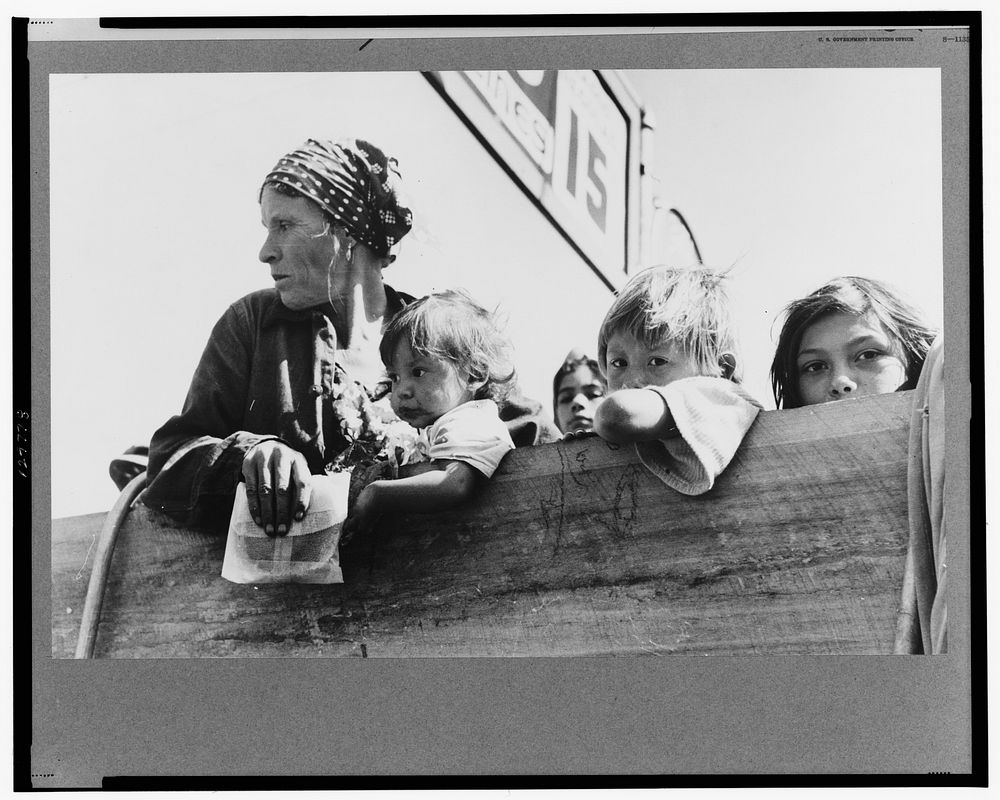 Mexican woman and children looking over side of truck which is taking them to their homes in the Rio Grande Valley from…