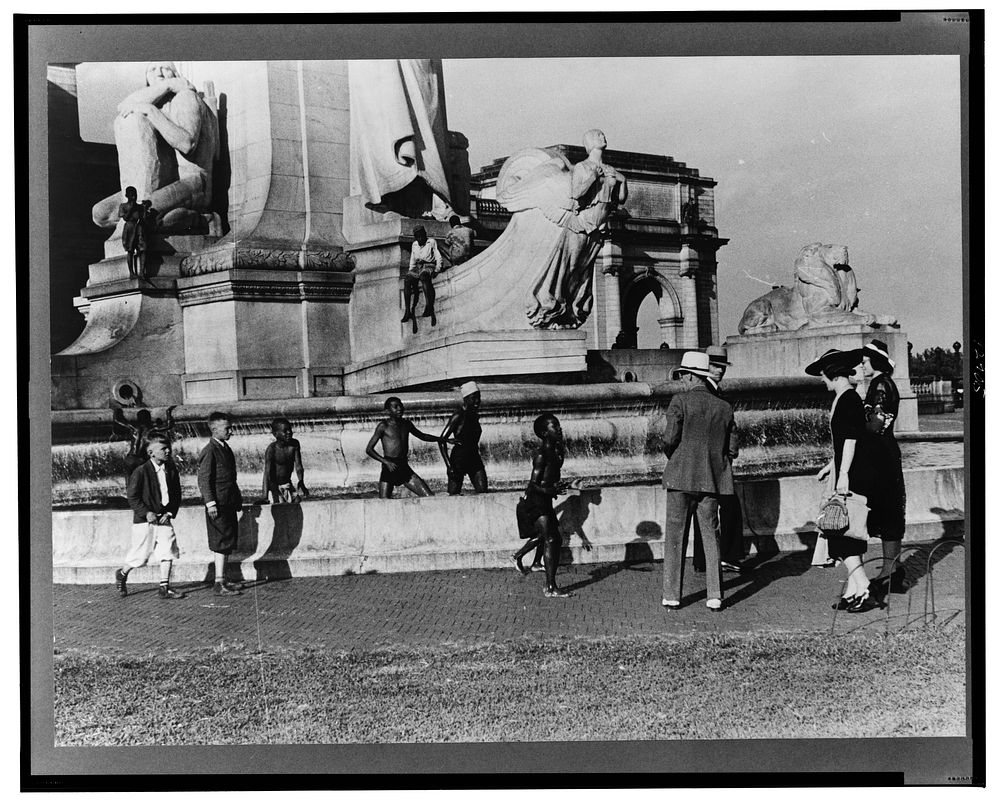 Tourists arriving at Washington, D.C. Throwing pennies to  boys in fountain across from Union Station. Sourced from the…