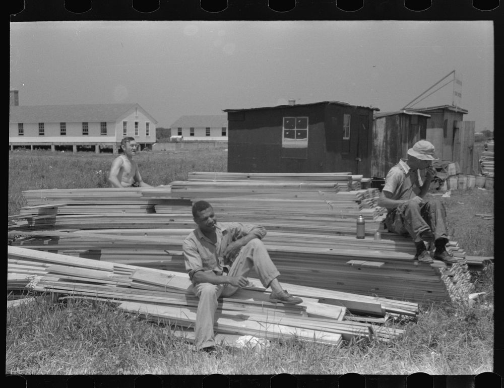 [Untitled photo, possibly related to: Workers during lunch hour putting up prefabricated defense houses managed by FSA (Farm…