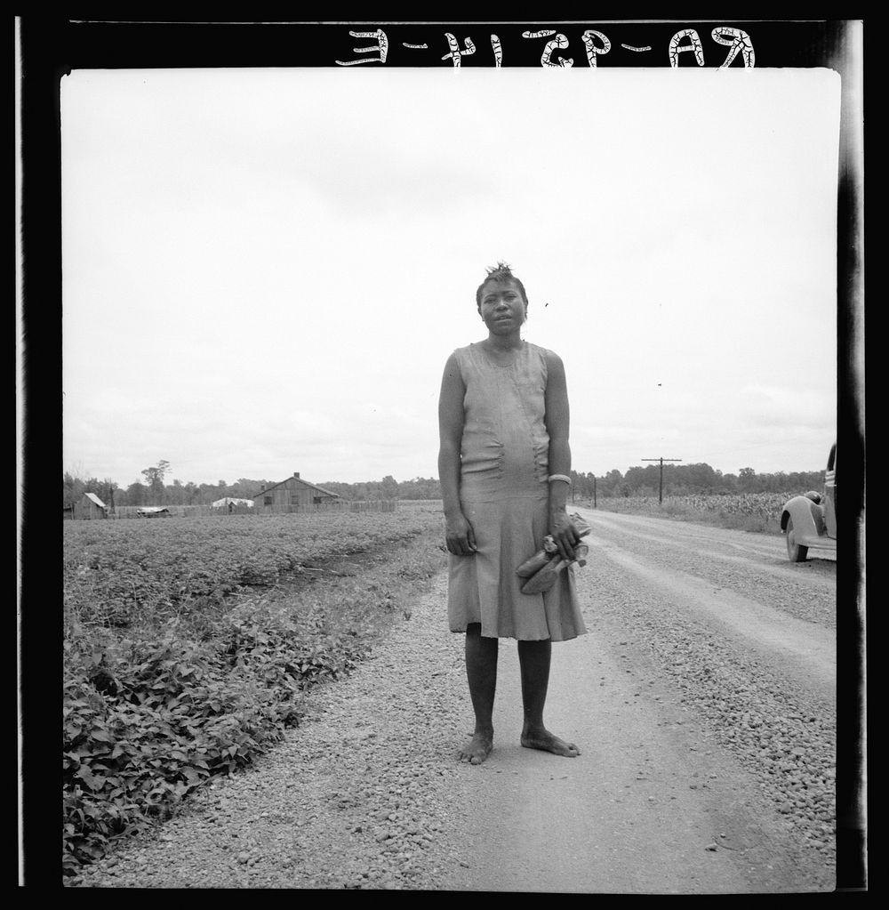  woman carrying her shoes home from church. Mississippi Delta by Dorothea Lange