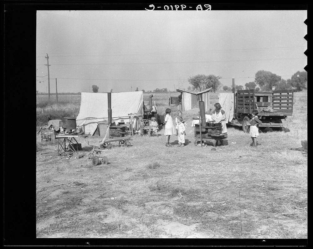 Wife and five children of migratory fruit worker. American River camp on outskirts of Sacramento, California. Have worked in…
