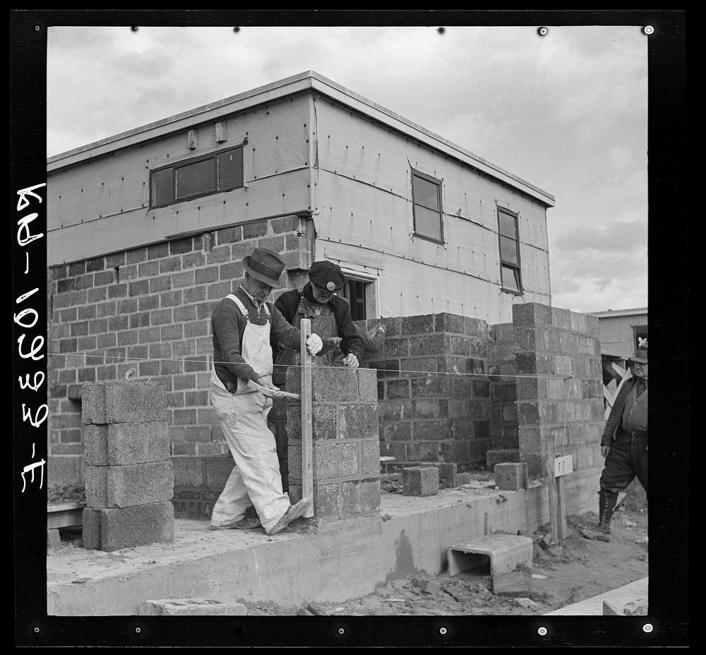 Houses under construction at the Greenhills project. Using the level to lay cinder blocks. Ohio by Russell Lee