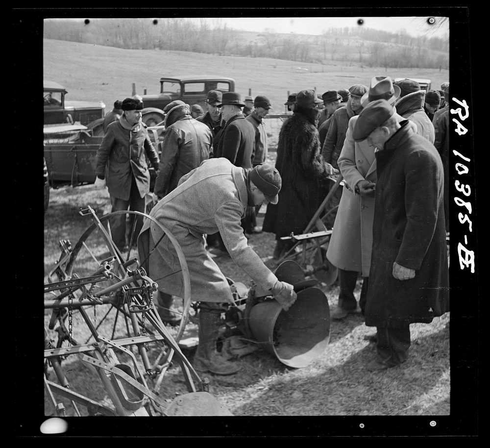 Prospective buyer inspecting a feed grinder at Frank Sheroan's closing-out sale near Montmorenci, Indiana by Russell Lee