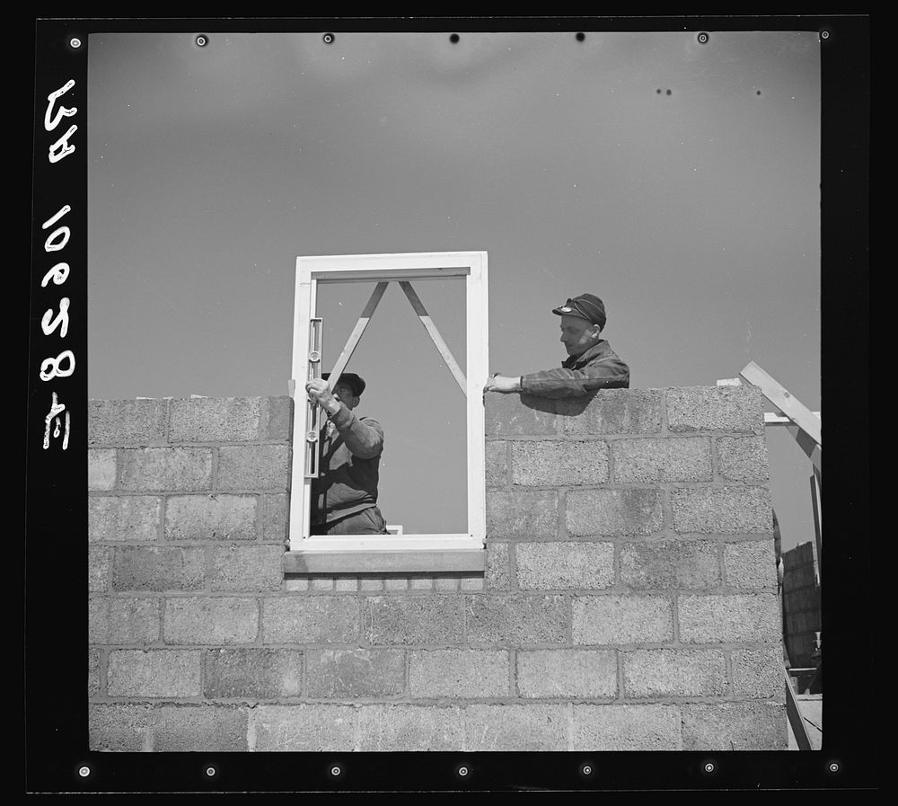 Putting window frame in place. Greendale, Wisconsin by Russell Lee