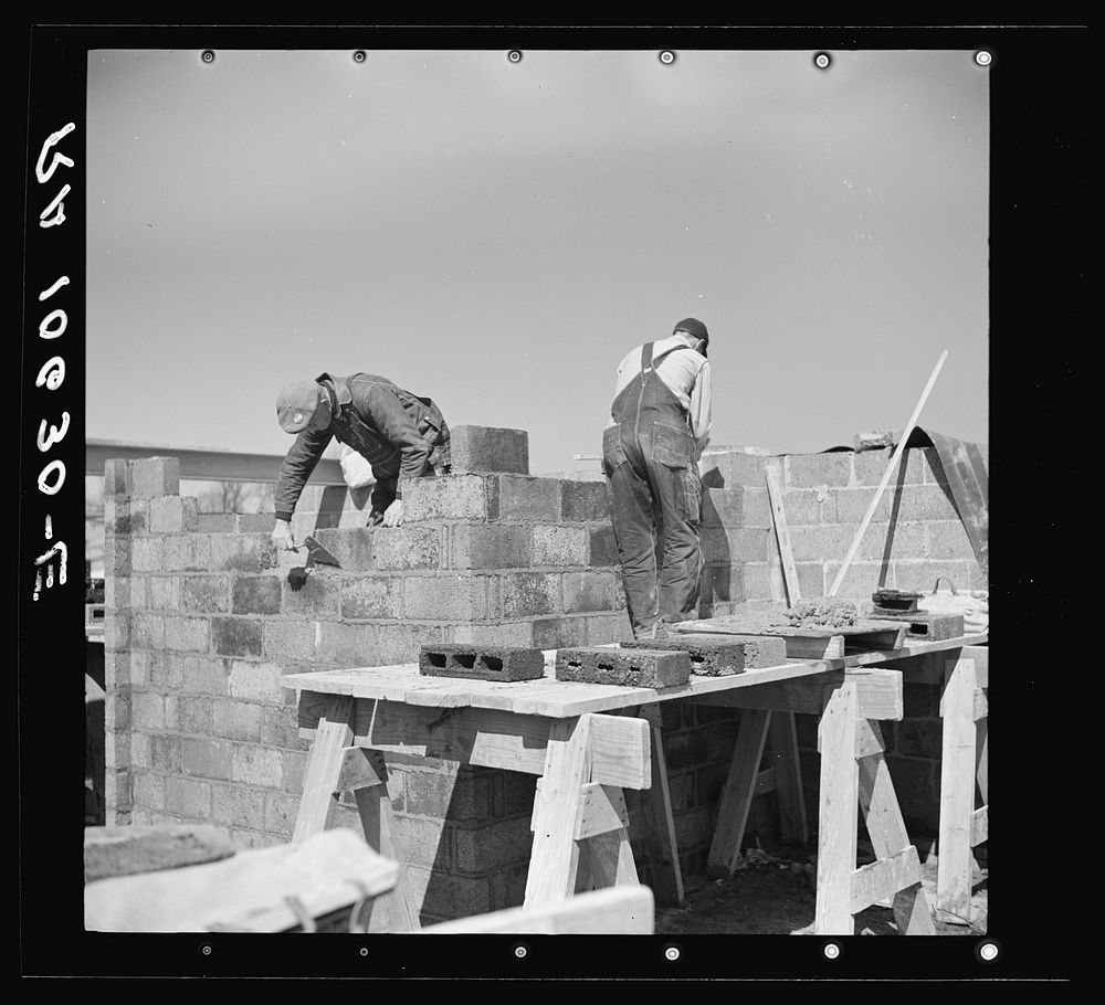 Laying cinder blocks on a house under construction at Greendale, Wisconsin by Russell Lee