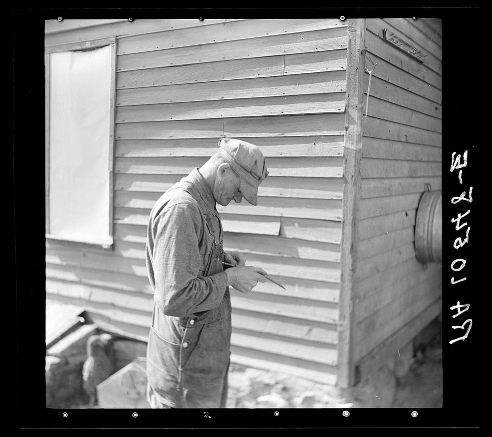 Tip Estes, forty-three year old hired man and father of nine children, whittling on a piece of wood. Near Fowler, Indiana by…