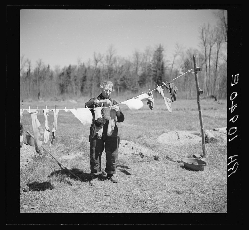 John Bastia hanging up his laundry. He is a single shacker in Iron County, Michigan by Russell Lee