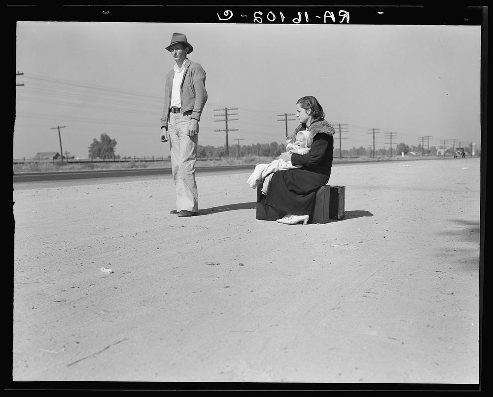 Young family, penniless, hitchhiking on U.S. Highway 99, California. The father, twenty-four, and the mother, seventeen…