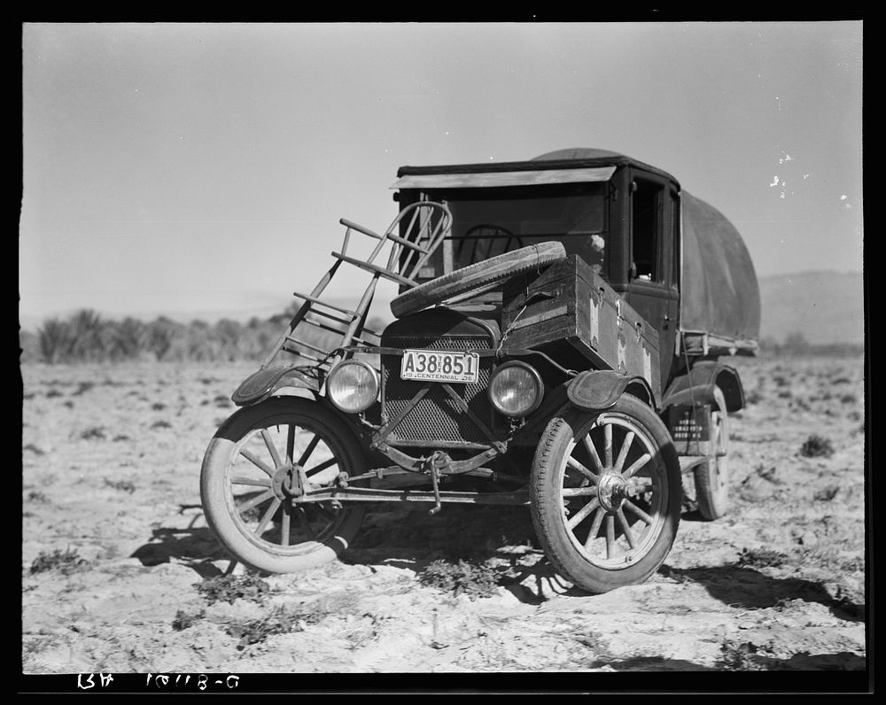 Texan refugees' car. They are seeking work in the carrot fields of the Coachella Valley. California by Dorothea Lange