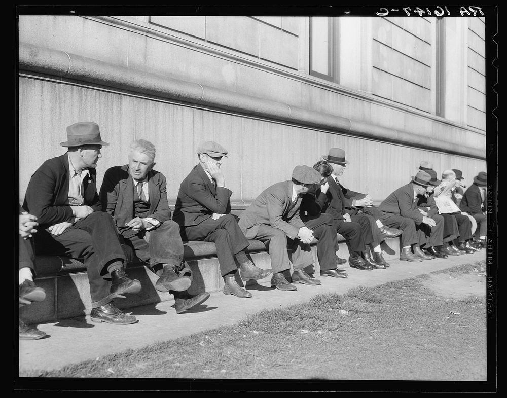Unemployed men sitting on the sunny side of the San Francisco Public Library. California. Sourced from the Library of…