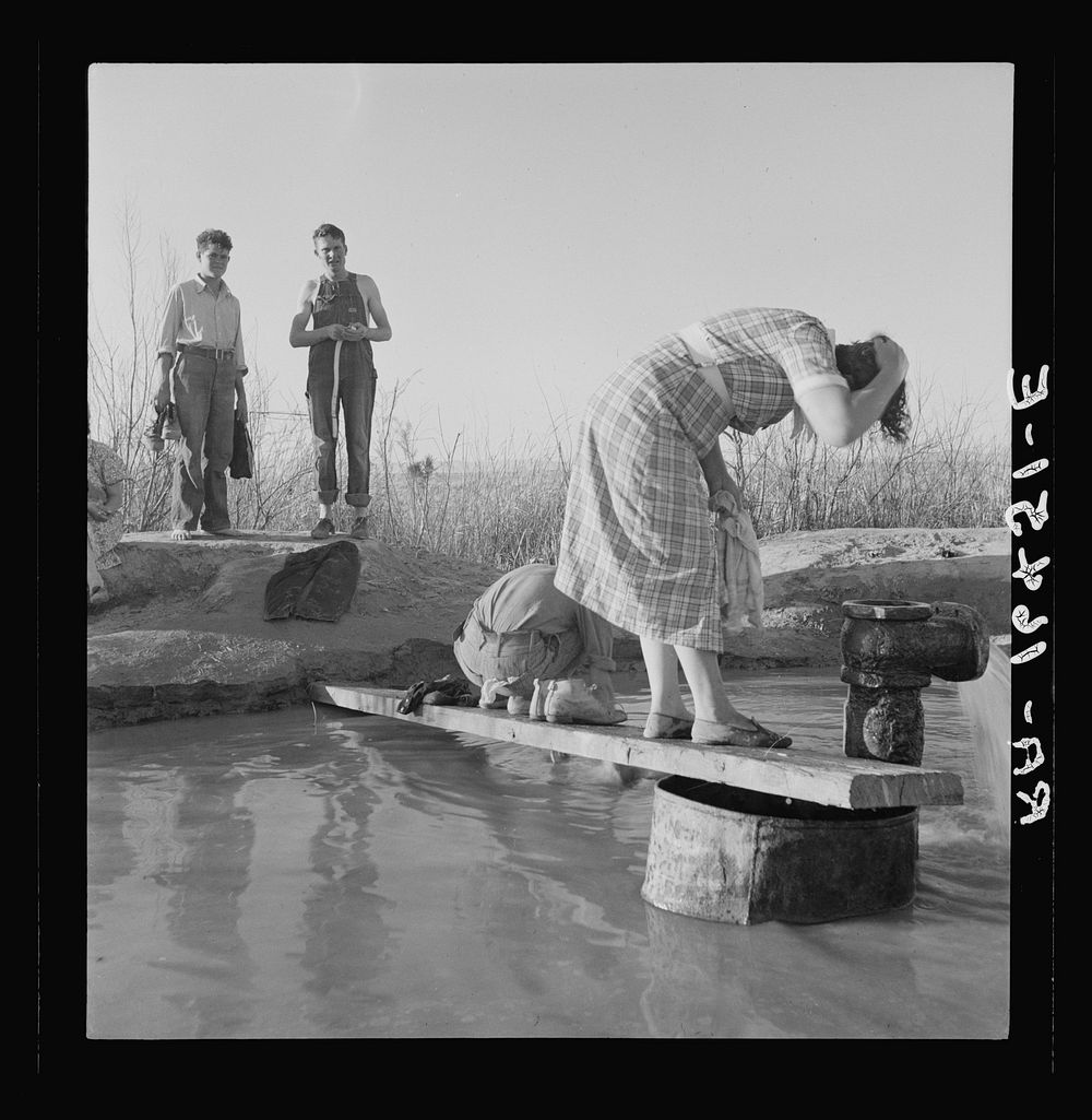 Oklahoma migratory workers washing in a hot spring in the desert. Imperial Valley, California. Sourced from the Library of…
