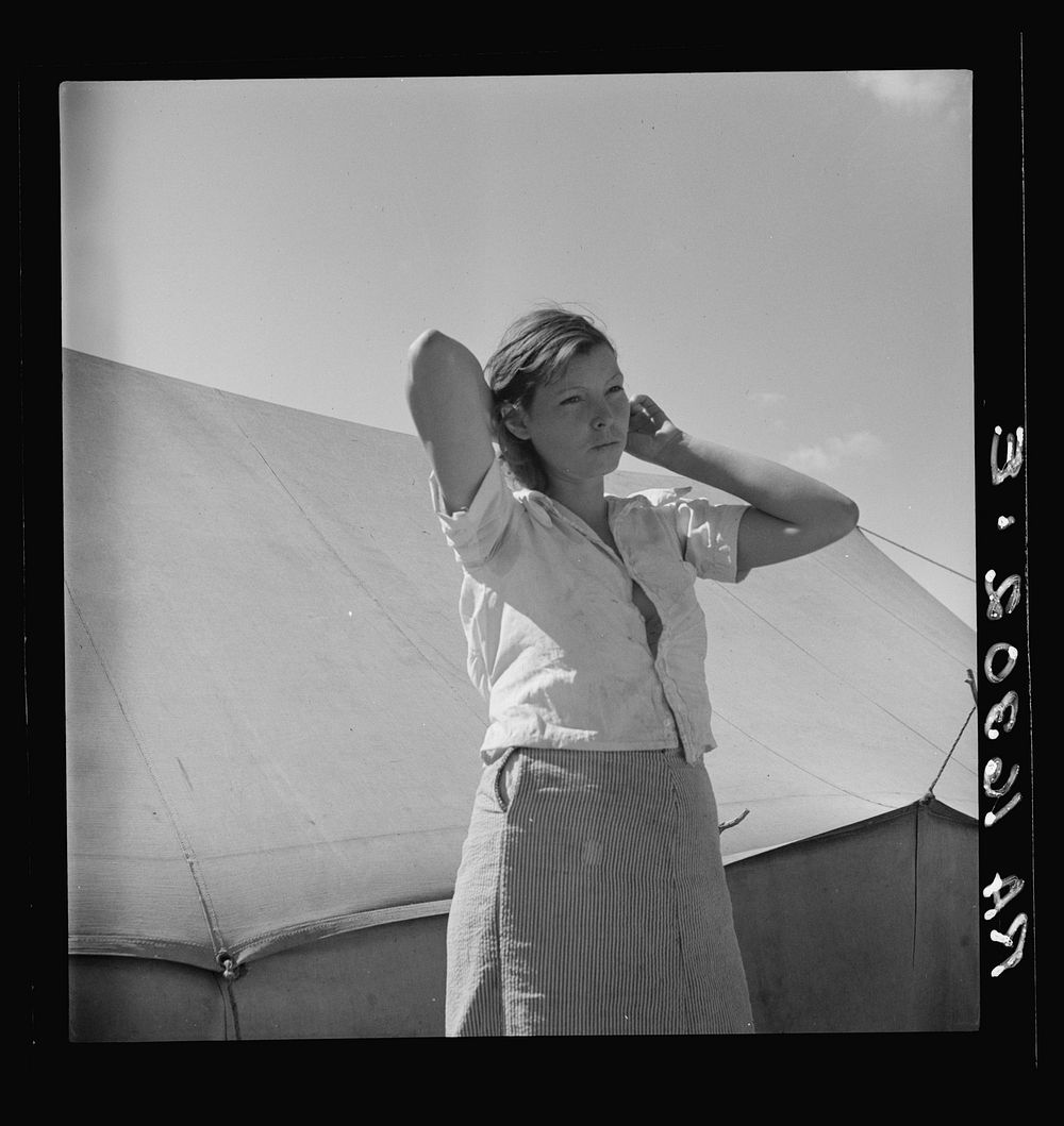 Woman in pea picker's camp. California. "I seen our corn dry up and blow over the fence back there in Oklahoma" by Dorothea…