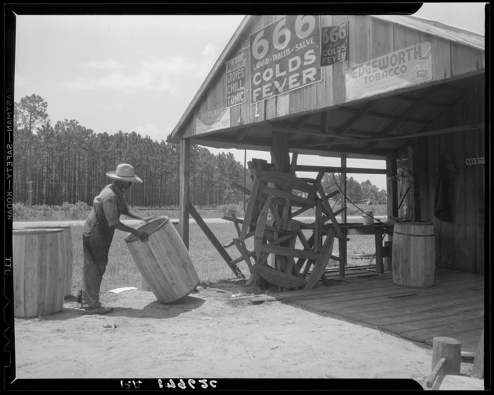 Turpentine still near Valdosta, Georgia. The "cooper" makes barrels to hold the gum. Sourced from the Library of Congress.