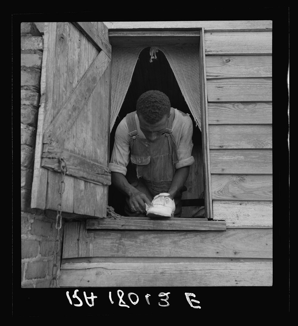 Negro field hand getting ready to go to town on a Saturday afternoon. His wages seventy-five cents a day and cabin. He has…