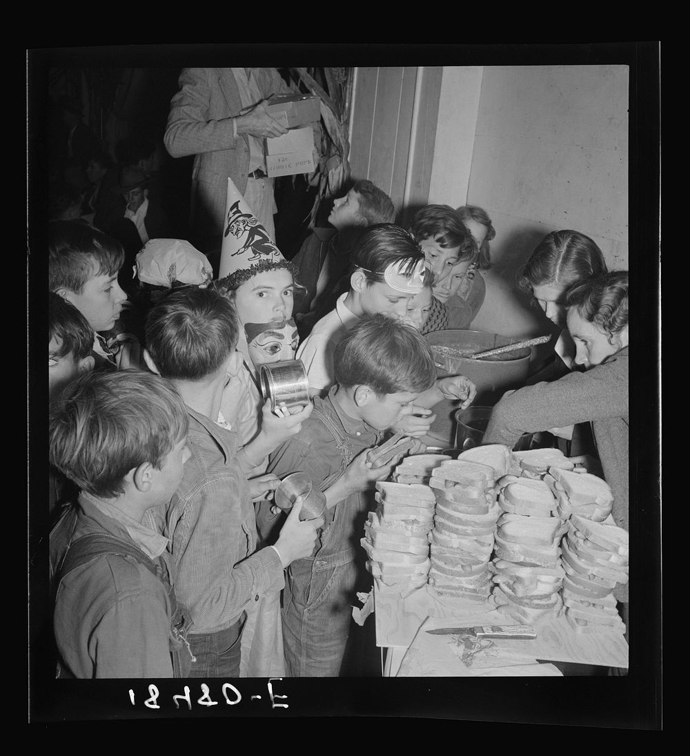 The children crowd and push to reach the refreshments at Halloween party in Shafter migrant camp. California by Dorothea…