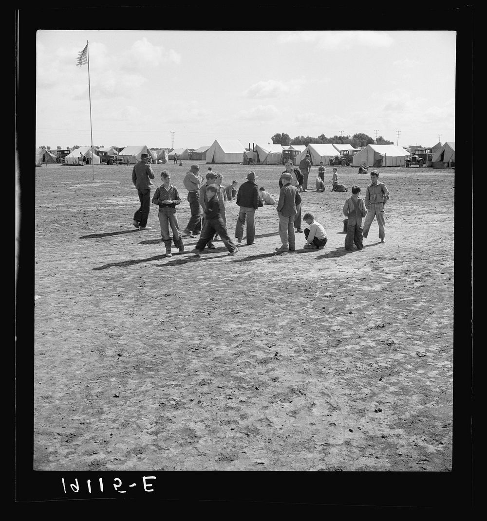 Marble time in Farm Security Administration (FSA) migratory labor camp (emergency.) Plenty of space to play and plenty of…