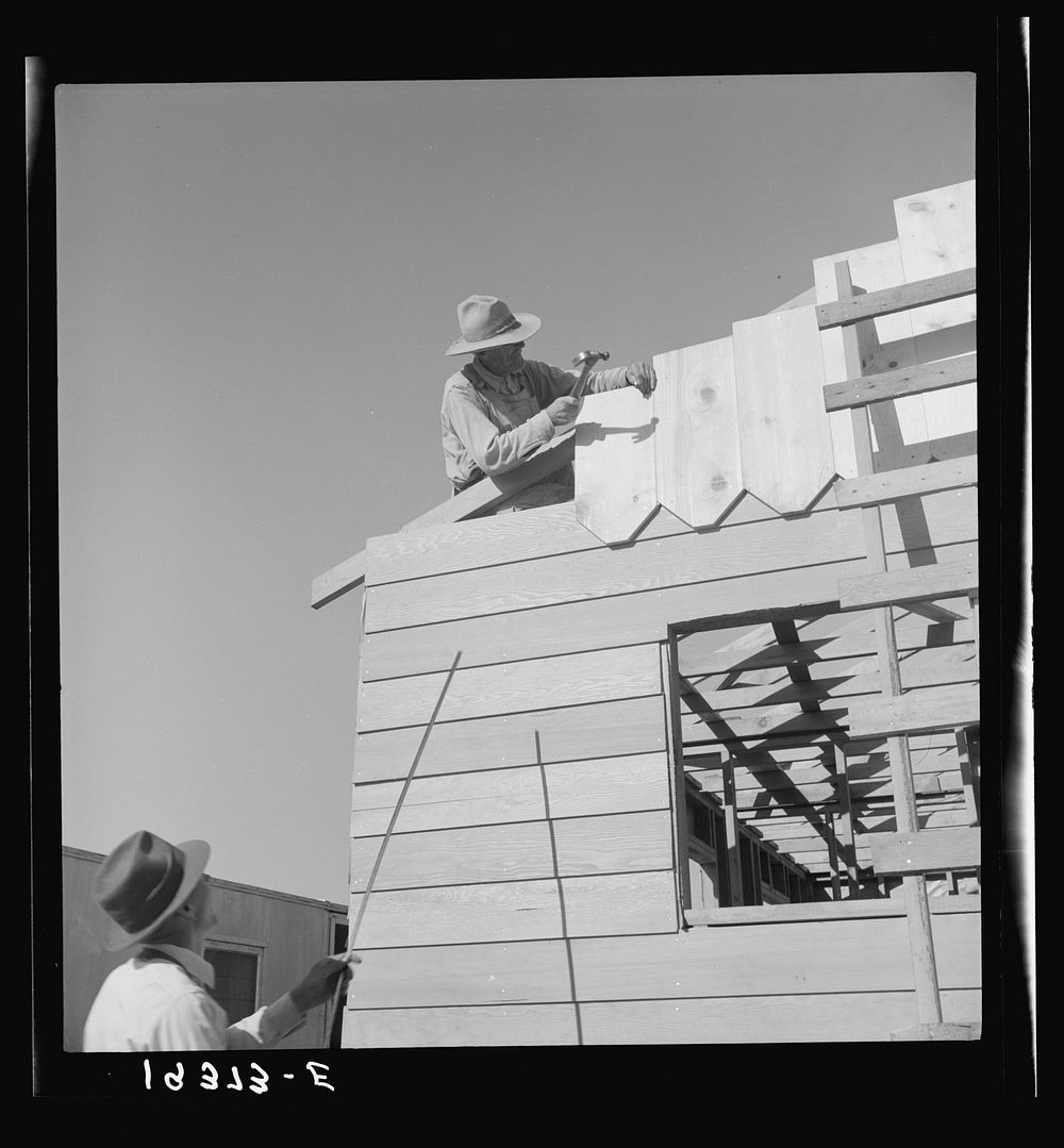 [Untitled photo, possibly related to: Father and son, recent migrants to California, building house in rapidly growing…
