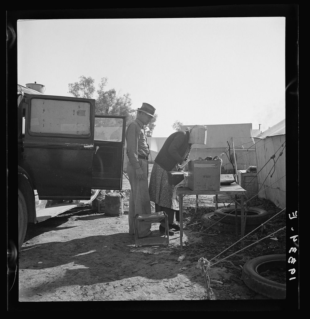 In a carrot puller' camp near Holtville, Imperial Valley, California. Migratory laborers from Texas, packing up to leave…