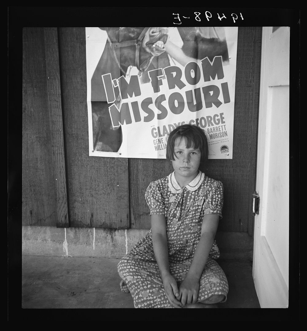 Advertisement for current movie in town. Westley, California. The child is a flood refugee from southeast Missouri by…