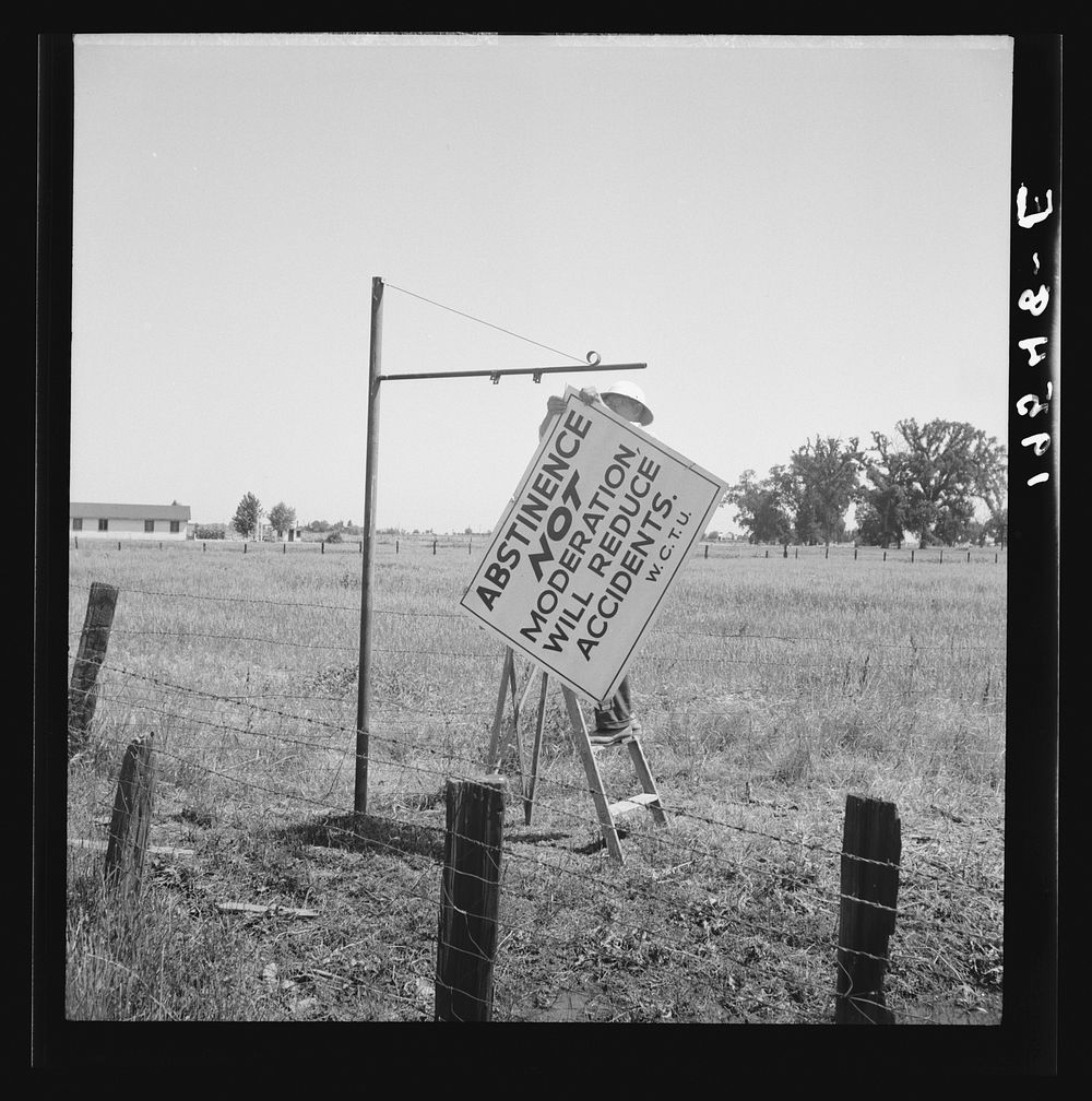 Near Hanford, California. See general caption. On U.S. 99. A member of the committee from adjoining town erects sign on the…