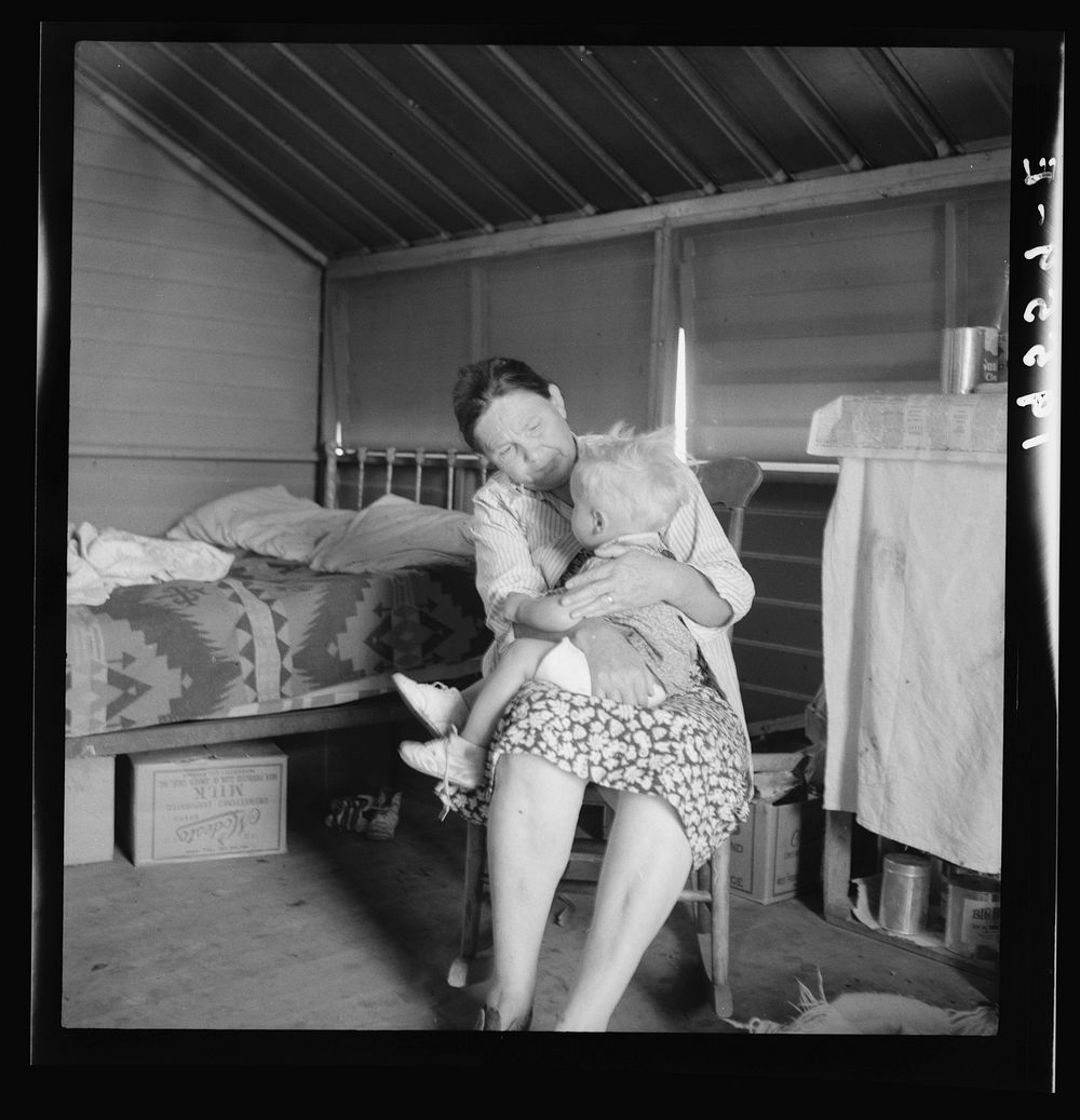 Tulare County. In Farm Security Administration (FSA) camp. Mother from Oklahoma tends baby with dysentery, and awaits…