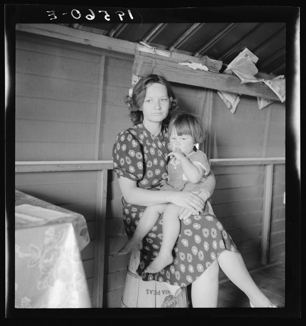 Tulare County, California. In Farm Security Administration (FSA) camp for migratory agricultural workers. Mother with sick…
