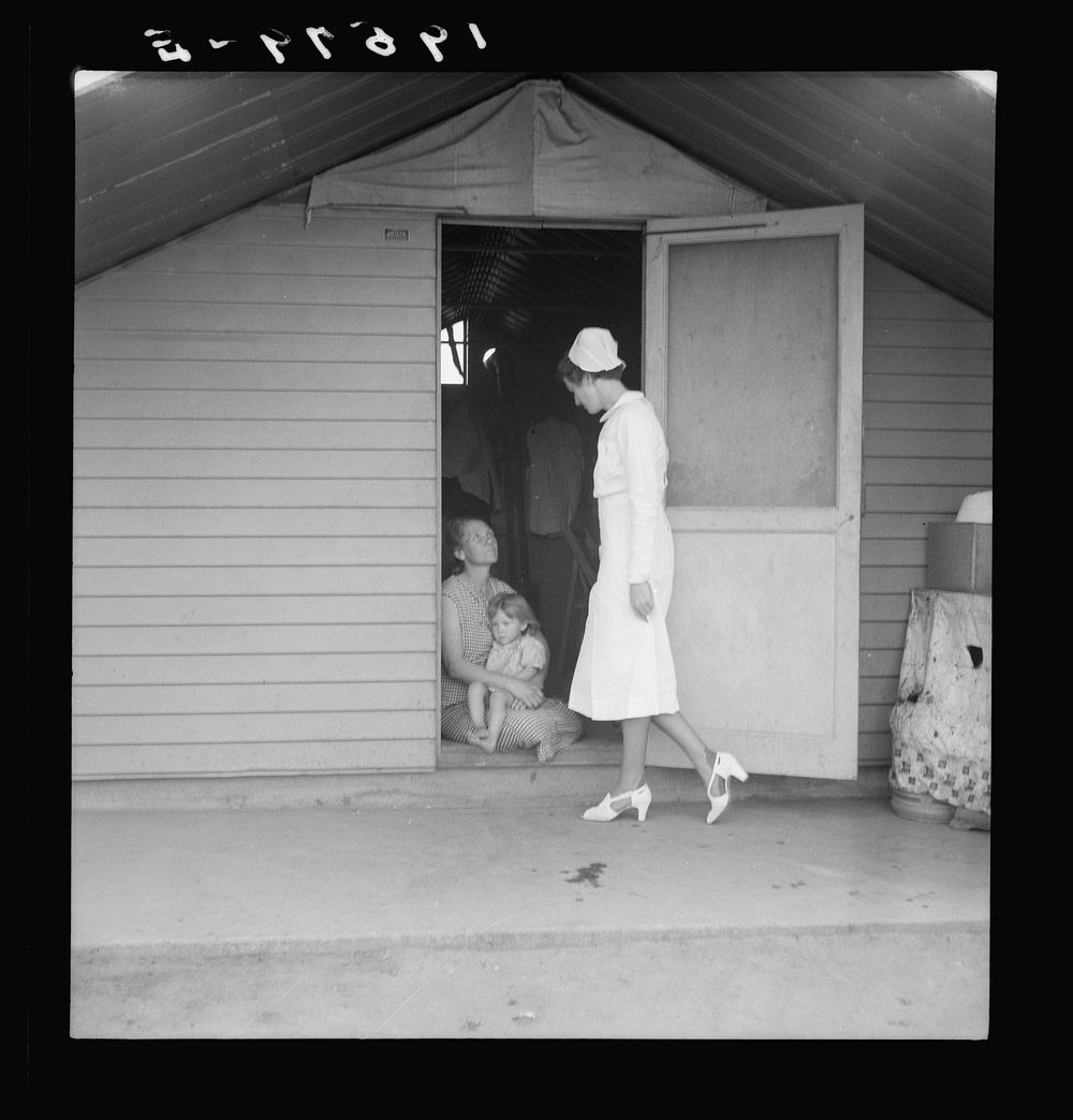 Farm Security Administration camp (FSA). Farmersville, Tulare County. Shows resident nurse come to visit family where there…