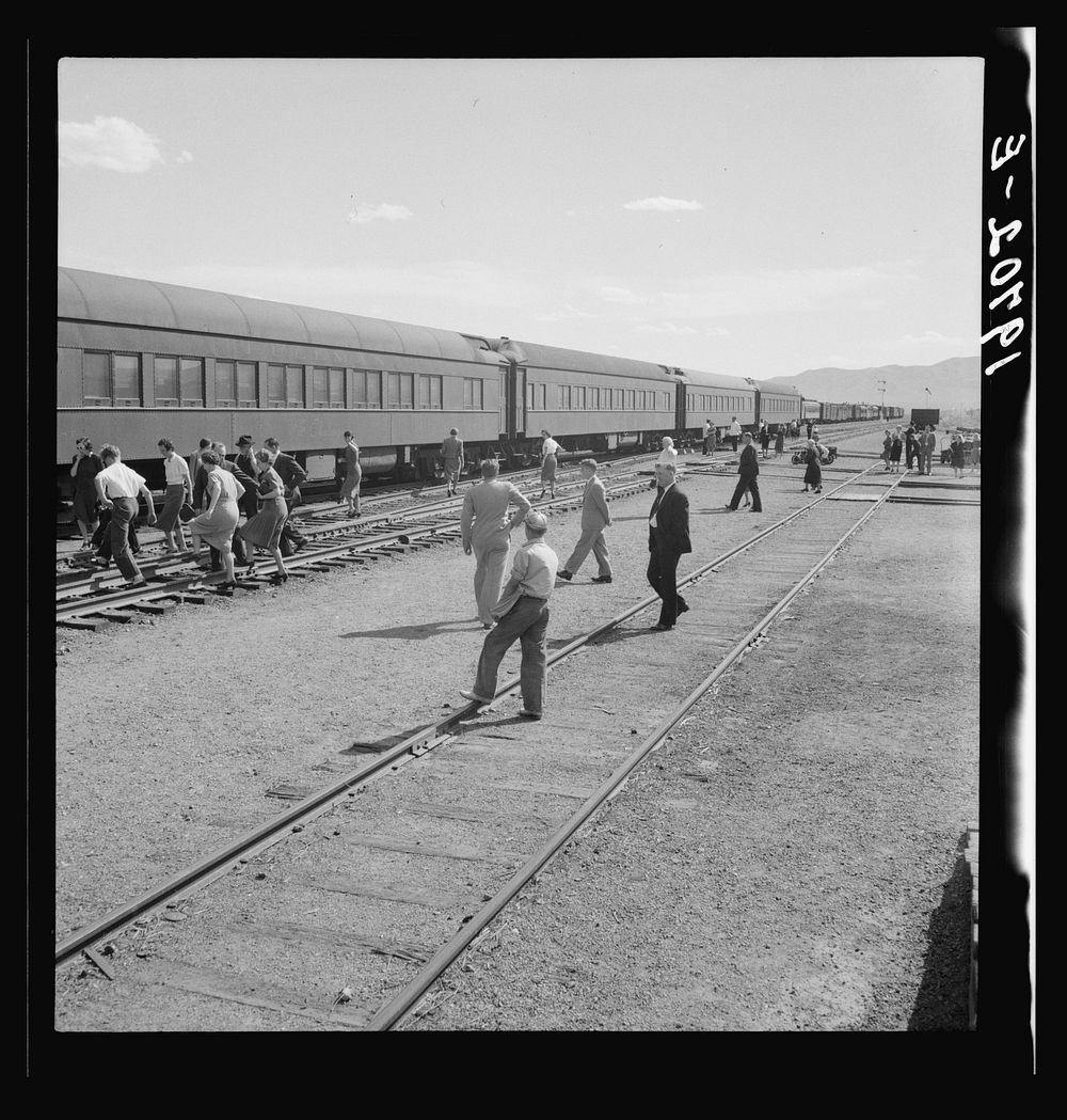 Railroad yards, Kearney, Nebraska. Overland train passengers go back to their cars after ten minute train stop on trip…