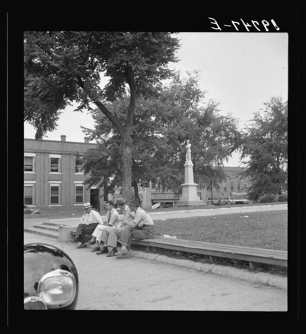 Men idling around the courthouse square. Note Confederate monument characteristic of Southern towns. Roxboro, North…