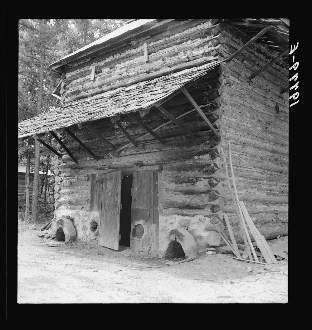 Tobacco barn with newly plastered furnace in preparation for "putting in."  Note main roof of tin and shelter roof of…