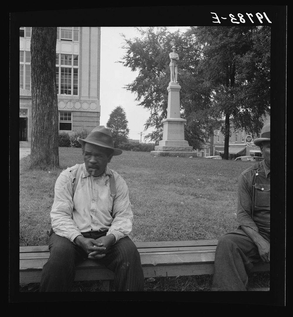 [Untitled photo, possibly related to: Men idling around the courthouse square. Note Confederate monument characteristic of…